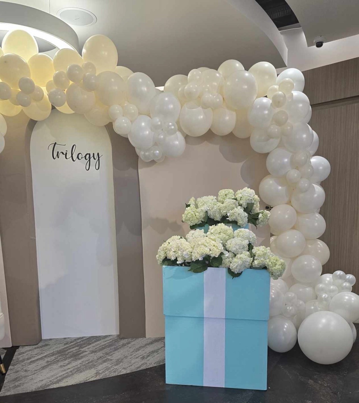 White balloon and floral celebration backdrop